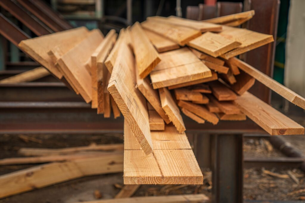 A close-up view of stacked hardwood lumber in a carpentry workshop, showcasing woodworking materials.